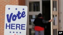 FILE - A polling worker enters a polling place in Charlotte, N.C., April 24, 2019, as early voting began in the Republican primary election for the North Carolina 9th Congressional District, a special election forced by a ballot-collection scandal.