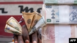 Un cambiste expose des billets dans sa cabine sur un marché de Kinshasa le 11 août 2021.