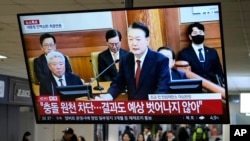 A TV screen shows footage of impeached South Korean President Yoon Suk Yeol's address at the final hearing of his trial during a news program at a bus terminal in Seoul, South Korea, Feb. 25, 2025.