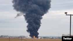 Black smoke rises after a World War II-era B-17 bomber crashes at Bradley International Airport, in Hartford, Connecticut, Oct. 2, 2019. (Source - Twitter @WFSBnews)