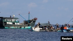 Sebuah kapal penangkap ikan China berlabuh di samping kapal penangkap ikan Filipina di Scarborough Shoal yang disengketakan 6 April 2017. Gambar diambil 6 April 2017. (Foto: dok). Sepanjang Desember 2020 terdapat 51 awak dari Indonesia terkatung-katung di perairan China.