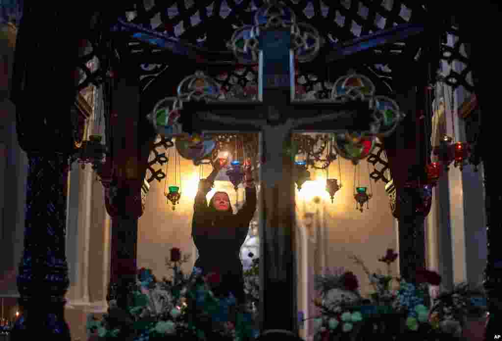 An Orthodox Church believer lights candles before the liturgy, on Orthodox Christmas Eve in the Prechistensky, the Cathedral Palace, in Vilnius, Lithuania.