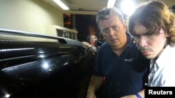 Ray Whelan (L), of Switzerland-based Match Services, arrives at a police station after being arrested in connection with the illegal resale of tickets at the World Cup, in Rio de Janeiro, July 7, 2014. 