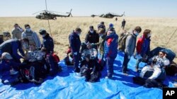 Astronaut AS Andrew Morgan (kiri), Jessica Meir (kanan), dan kosmonaut Rusia Oleg Skripochka duduk sesaat setelah mendarat dengan kapsul ruang angkasa Soyuz MS-15 dekat Dzhezkazgan, Kazakhstan, 17 April 2020.