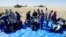 In this handout photo by the Roscosmos space agency, U.S. astronauts Andrew Morgan, left, Jessica Meir, right, and Russian cosmonaut Oleg Skripochka sit shortly after landing in a Soyuz MS-15 space capsule near Dzhezkazgan, Kazakhstan, April 17, 2020.