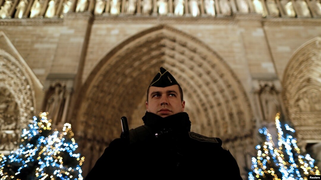 Francuski žandarm na straži. Jake policijske snage obezbeđuju prilaze katedrali Noterdam tokom proslave Božića u Parizu (REUTERS/Christian Hartmann - RTX2WDZR)