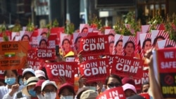 Anti-coup protesters hold up signs that read "Join in CDM (Civil Disobedience Movement)'' during a rally near the Mandalay Railway Station in Mandalay, Myanmar, Feb. 22, 2021.