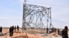 FILE - Nigerian security forces are seen on the site of a sabotage attack against electrical infrastructures on the outskirts of Maiduguri, Feb. 12, 2021. Another attack knocked out power again March 27, 2021. 