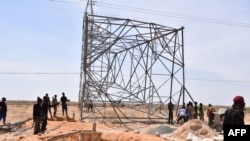 FILE - Nigerian security forces are seen on the site of a sabotage attack against electrical infrastructures on the outskirts of Maiduguri, Feb. 12, 2021. Another attack knocked out power again March 27, 2021. 