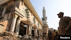 FILE - An army soldier and rescue workers on Jan. 31, 2023, survey the damage caused by a suicide blast in a mosque in Peshawar, Pakistan.