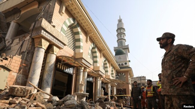 FILE - An soldier and rescue workers survey damage after a suicide blast in a mosque in Peshawar, Pakistan, January 31, 2023.