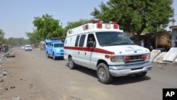 FILE - An ambulance and security vehicles are seen driving to the site of a June 2, 2015, suicide bomb attack in Maiduguri, Nigeria.