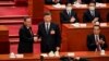 El presidente de China, Xi Jinping (centro), da la mano al recién elegido primer ministro Li Qiang (izquierda) mientras el exprimer ministro Li Keqiang (derecha) aplaude durante la cuarta sesión plenaria de la Asamblea Popular Nacional (APN), en Beijing, el 11 de marzo de 2023.