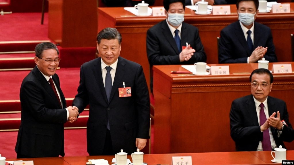 中国领导人习近平和新总理李强在全国人大会议期间握手，李克强在旁。（2023年3月11日）(photo:VOA)