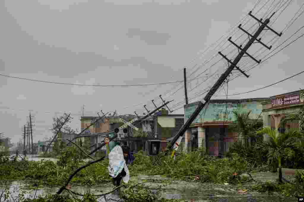 Líneas eléctricas caídas y ramas de árboles en una calle después de que el huracán Ian azotara Pinar del Río, Cuba, el martes 27 de septiembre de 2022. Ian tocó tierra a las 4:30 a.m. EDT del martes en la provincia cubana de Pinar del Río, donde las autoridades instalaron albergues, enviaron personal de emergencia y tomaron medidas para proteger los cultivos de tabaco. (Foto AP/Ramón Espinosa)