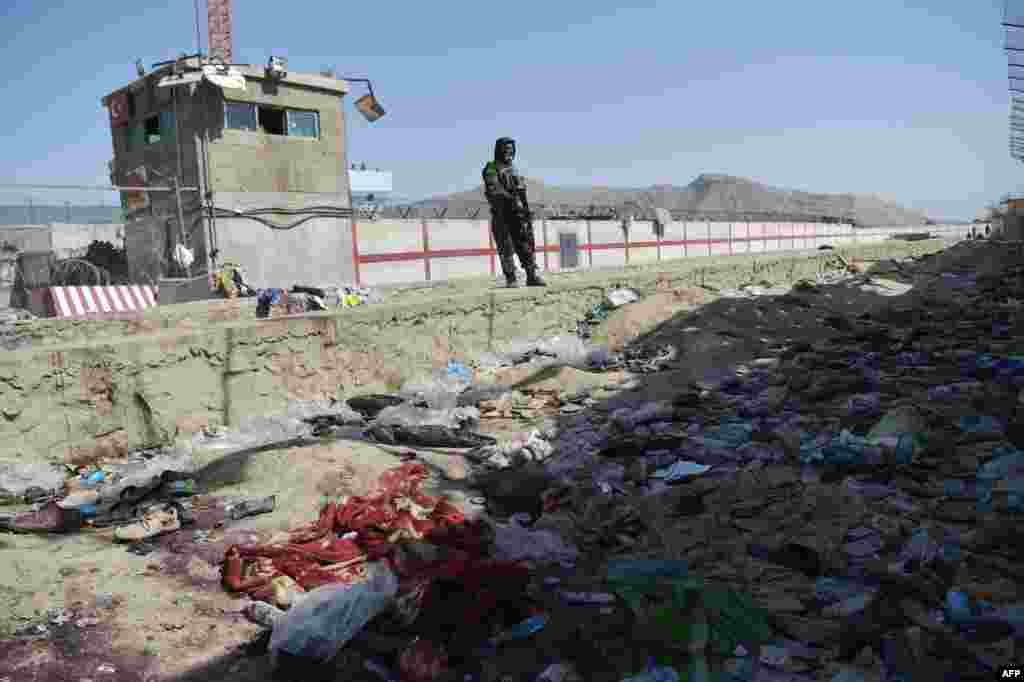 아프가니스탄 탈레반 대원이 카불 국제공항 외곽 자살 폭탄 테러 현장을 지키고 있다.