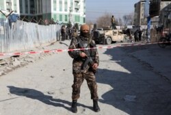 FILE - An Afghan security officer stands guard at the site of a bomb blast in Kabul, Dec. 15, 2020.