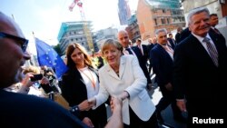 10月3日，德國總理默克爾（中）和總統高克（右）在法蘭克福街頭與民眾慶祝國家統一25週年。