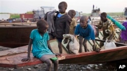 A group of displaced brothers and sisters cautiously disembark from a boat that has just carried them across the Nile to a village in Awerial, which has received tens of thousands of displaced people who crossed the Nile river by boat to flee the recent f