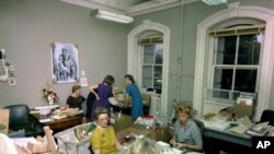 Nancy Tuckerman (teal dress) and volunteers help answer condolence and Christmas mail, Executive Office Building, 11 December 1963.