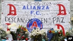 Ofrendas florares y condolencias rinden tributo a los aficionados que murieron en una estampida en el estadio Cuscatlán de San Salvador, El Salvador, el lunes 22 de mayo de 2023. 