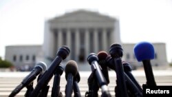 FILE - News microphones wait to capture reactions from US Supreme Court rulings outside the court building in Washington.