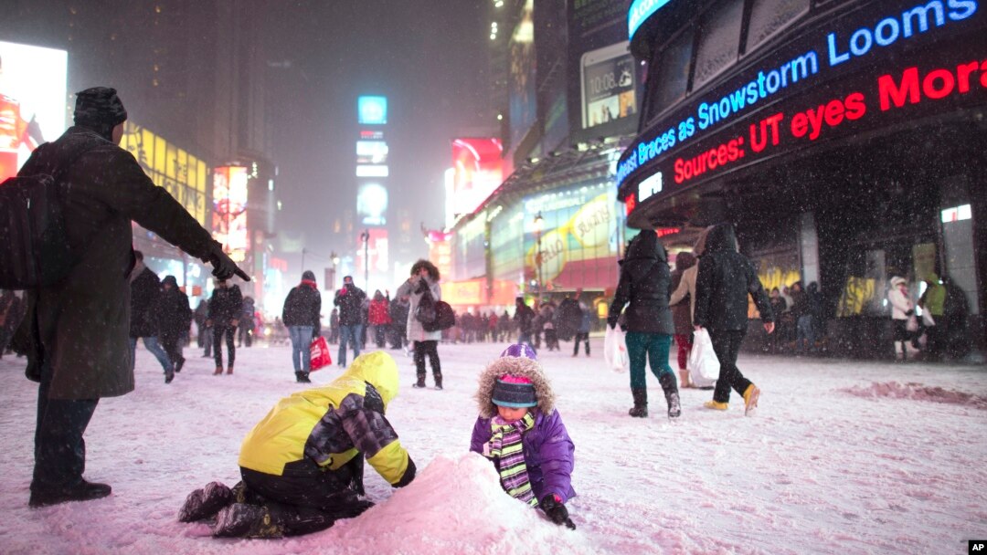 Anak-anak bermain salju di Times Square, New York (2/1). 