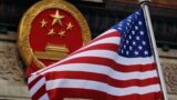 FILE - In this Nov. 9, 2017, file photo, an American flag is flown next to the Chinese national emblem during a welcome ceremony for visiting U.S. China says accusations against an alleged spy of attempting to steal trade secrets from several American avi