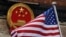 FILE - In this Nov. 9, 2017, file photo, an American flag is flown next to the Chinese national emblem during a welcome ceremony for visiting U.S. China says accusations against an alleged spy of attempting to steal trade secrets from several America