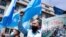 FILE - Demonstrators from the Uyghur community gesture as they take part in a protest near the Belgium parliament in Brussels, July 8, 2021. 