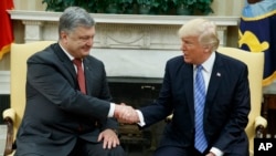President Donald Trump, right, shakes hands with Ukrainian President Petro Poroshenko during a meeting in the Oval Office of the White House, June 20, 2017, in Washington. 