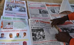 A man arranges local newspapers that he sells in a street in Niamey, Niger, Dec. 28, 2020, a day after Nniger's general elections.