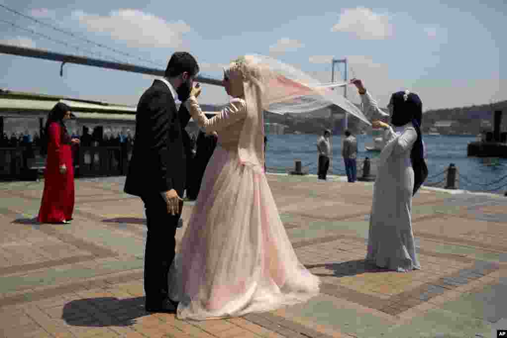 Pasangan pengantin baru berfoto di depan jembatan Bosporous di Istanbul, Turki pasca aksi kudeta yang gagal.