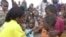 FILE - A World Health Organization official dispenses polio vaccine in Tosweyn village, Somalia. Investing in children's health and education spurs countries' economic development, a new U.N. report says.  