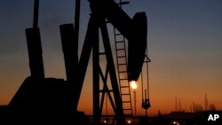 FILE - An oil pump is seen at sunset, in the desert oil fields of Sakhir, Bahrain, Jan. 18, 2016. The political stability of the six Gulf states -- Saudi Arabia, the United Arab Emirates, Qatar, Kuwait, Bahrain and Oman -- is rooted in profits from fossil fuels.