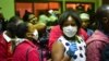 FILE - Travelers wearing face masks as protective measure wait to get their temperature checked at the border post with Kenya in Namanga on March 16, 2020, on the day Tanzania confirmed the first case of COVID-19.