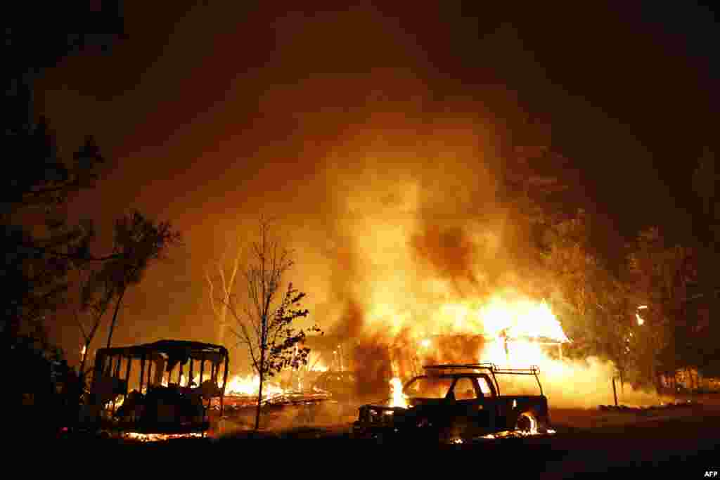 A car burns in front of a burning home during Valley Fire in Middletown, California, USA. The fast-moving fire has consumed 40,000 acres and is currently zero percent contained.