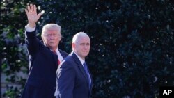 FILE - President Donald Trump, left, accompanied by Vice President Mike Pence, waves to members of the media as they walk to the Oval Office of the White House in Washington, Jan. 25, 2017