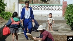 North Koreans are shown drying crops outside their homes at a collective farm located about 20 kilometers from the center of Pyongyang, 23 Sep 2010