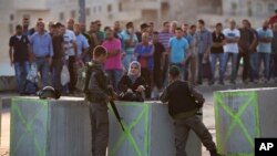 以色列边界警察正在检查从耶路撒冷阿拉伯社区出来的巴勒斯坦人的身份证件。