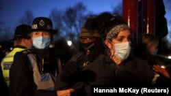 Seorang pengunjuk rasa bentrok dengan polisi ketika orang-orang berkumpul di sebuah situs peringatan di Clapham Common Bandstand, menyusul penculikan dan pembunuhan Sarah Everard, di London, Inggris, 13 Maret 2021. (Foto: REUTERS/Hannah McKay)