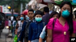 Warga mengenakan masker sebagai perlindungan terhadap merebaknya virus flu babi di Yangon, Myanmar (27/7). 