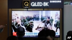 A TV screen shows an image of soldiers believed to be from North Korea standing in line to receive supplies from Russia during a news program at Seoul Railway Station in Seoul, Oct. 21, 2024. 