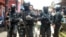FILE - Armed anti-terror police walk ahead of guard officers in March 2015 after searching the house of a man suspected of being involved in Islamic State-related activities in Indonesia's Banten province.