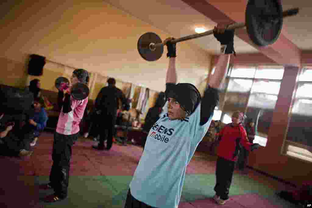 Shabnam Rahimi, 19, (blue) and her sister Sadaf, 18, (pink) lift weights during a practice in a boxing club in Kabul December 28, 2011. Female boxing is especially unusual in Afghanistan, where many girls and women still face a struggle to secure an educa