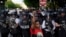 FILE - A demonstrator raises her fist to protest the death of George Floyd, near the White House, in Washington, May 30, 2020. Floyd, an African American, died after being restrained by Minneapolis police officers, triggering nationwide protests.