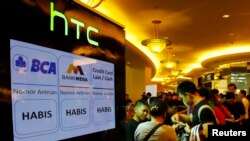 Orang-orang mengantre untuk membeli ponsel HTC One pada hari pertama penjualannya di Mal Taman Anggrek, Juni 2013. (Reuters/Beawiharta)