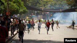 FILE - Protesters run from tear gas being fired by police during Irreecha, the thanks giving festival of the Oromo people in Bishoftu town of Oromia region, Ethiopia, October 2, 2016