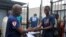 FILE - Cassius Kollie (R), 24, one of four people discharged from an Ebola treatment unit, receives a certificate for being cured of the disease in Paynesville, Liberia, July 20, 2015. 
