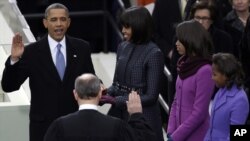 Presiden Barack Obama (kiri), disaksikan ratusan keluarganya dan ratusan ribu warga AS, mengambil sumpah jabatan. di depan gedung Capitol di Washington DC hari Senin (21/1). 